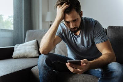 Understanding and Overcoming Men’s Pornography Addiction 9 man concerned with phone 717574465 1